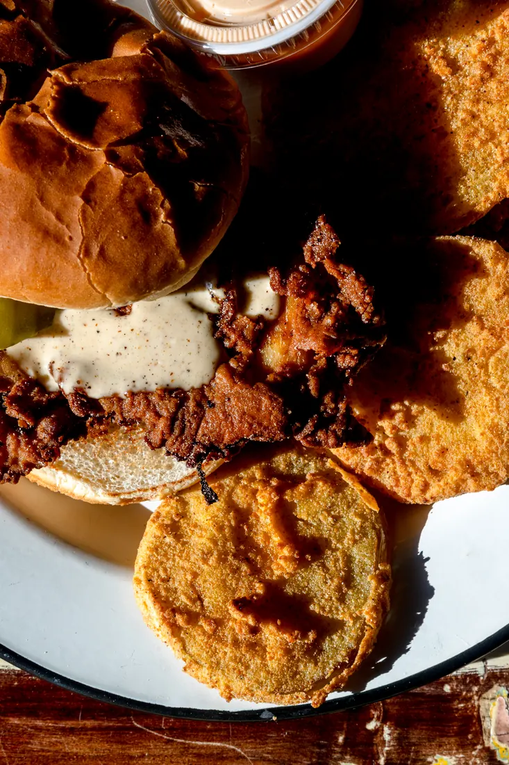 Fried chicken sandwich with white sauce and pickles